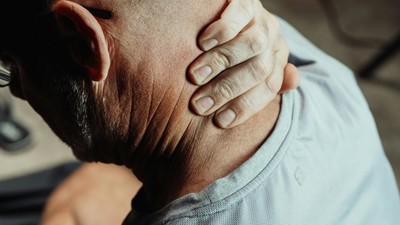 A man massaging a sore neck